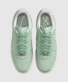 Mint green low-top sneakers with white sole and signature logo on tongue and insole, top view