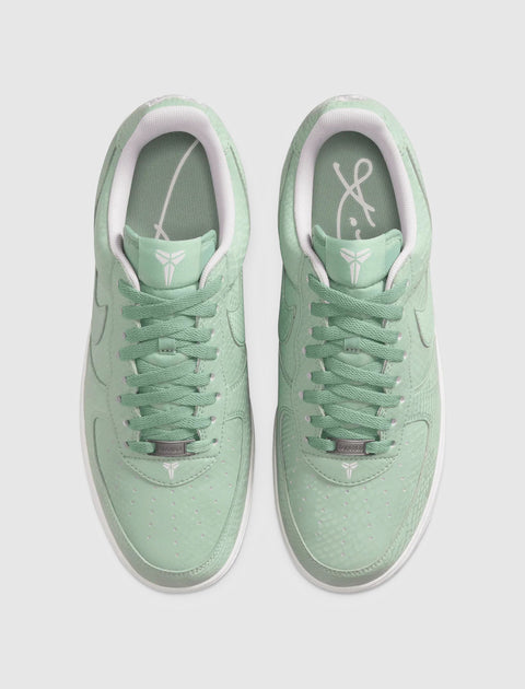 Mint green low-top sneakers with white sole and signature logo on tongue and insole, top view