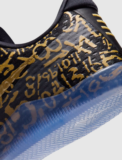 Close-up of black sneaker with gold graffiti-style text and translucent blue sole