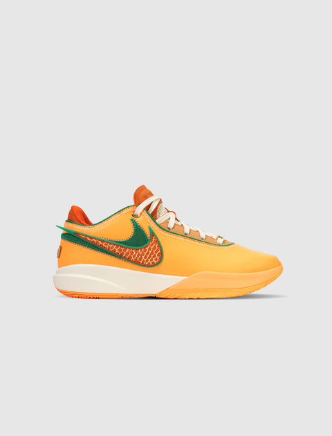Orange and green low-top sneaker with textured side swoosh on a white sole