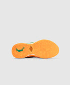 Sneaker with orange textured sole and green logo, streetwear athletic footwear