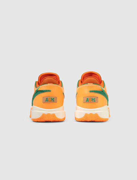 Orange and green low-top sneakers, back view, with A&M logo on heel, white soles