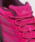 Close-up of vibrant magenta athletic sneaker with mesh upper and reflective laces