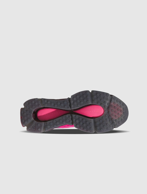 Black and magenta sneaker outsole with textured grip and circular tread pattern