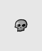 Black and gray enamel skull pin on a plain light background
