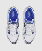 Top view of white mesh sneakers with blue accents and white laces on a white background