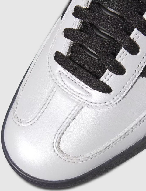 Close-up of silver leather sneaker toe with black laces and stitching details