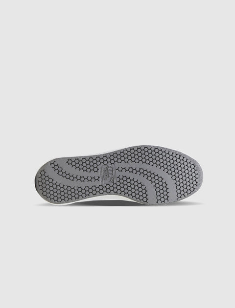 Gray sneaker sole with honeycomb traction pattern on white background