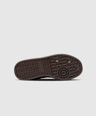 Close-up of black adidas sneaker sole with textured grip and logo on white background