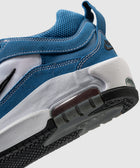 Close-up of blue and white sneaker with mesh upper, suede overlays, and visible sole details