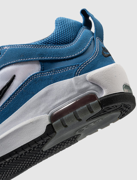 Close-up of blue and white sneaker with mesh upper, suede overlays, and visible sole details