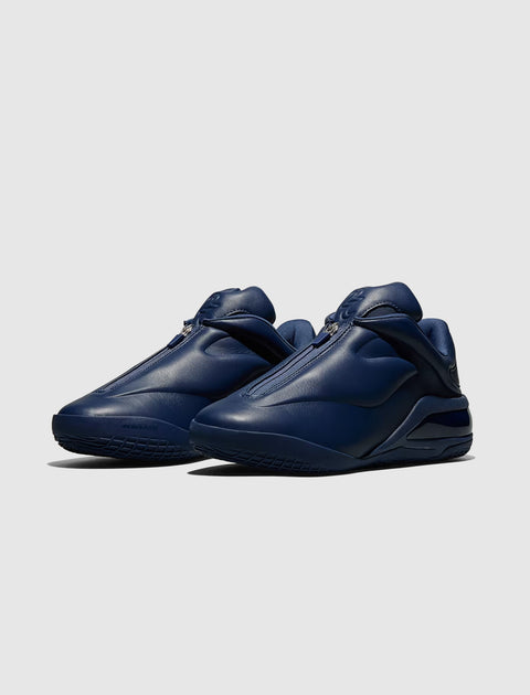 Men's navy blue leather sneakers with zipper closure and chunky sole on white background