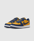 Yellow and navy low-top sneakers with perforated toe and white sole on white background