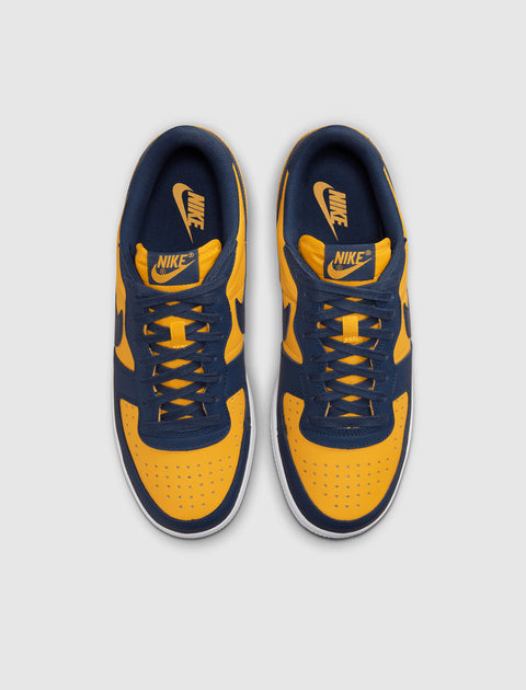 Yellow and navy low-top sneakers with Nike logo, viewed from above on a plain background