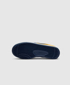 Close-up of navy blue sneaker sole with herringbone tread pattern on light background