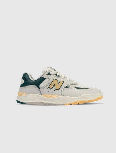 Cream and green low-top sneaker with yellow accents and chunky sole, side profile on white background.