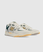 Men's beige and green sneakers with yellow accents and chunky sole on white background