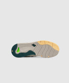 Beige and green sneaker outsole with yellow and green accents, tread pattern visible