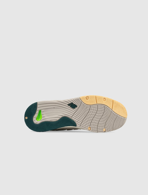 Beige and green sneaker outsole with yellow and green accents, tread pattern visible
