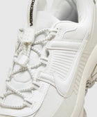 Close-up of a white athletic sneaker with unique lacing and VOMERO text on pull tab