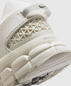 Close-up of white athletic sneaker heel with mesh details, textured sole, and Nike logo
