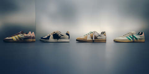 Four stylish men's sneakers with colorful stripes displayed against a modern gray background